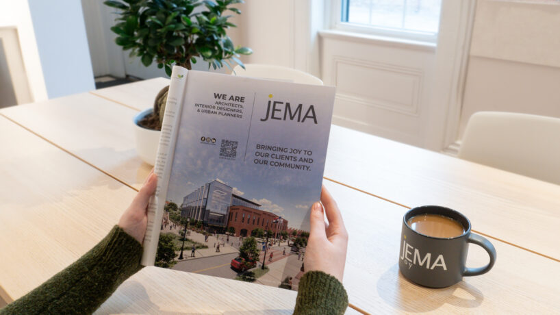 image of person holding a magazine with whole page JEMA ad printed